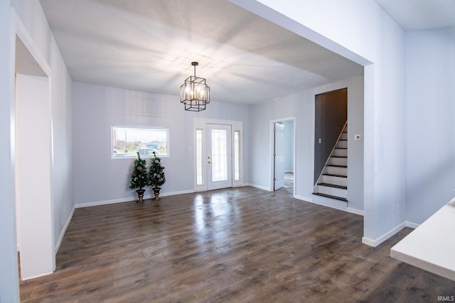 foyer with dark wood-type flooring and an inviting chandelier