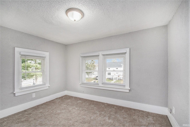 carpeted empty room with a textured ceiling