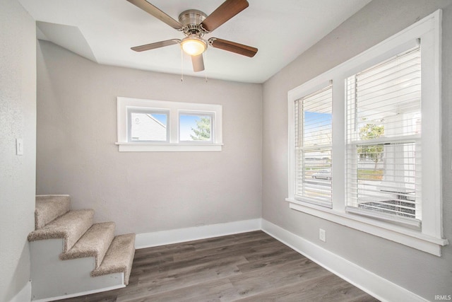 unfurnished room with dark hardwood / wood-style floors, ceiling fan, and a wealth of natural light