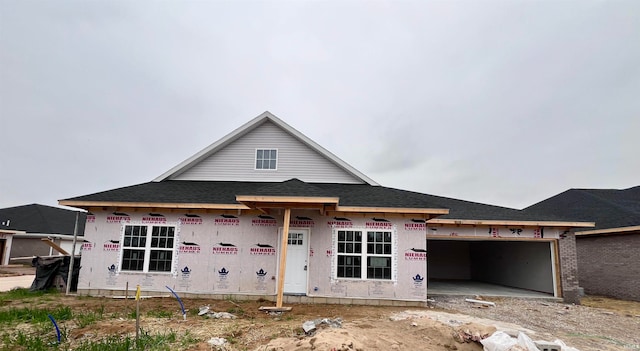 property in mid-construction featuring roof with shingles and an attached garage