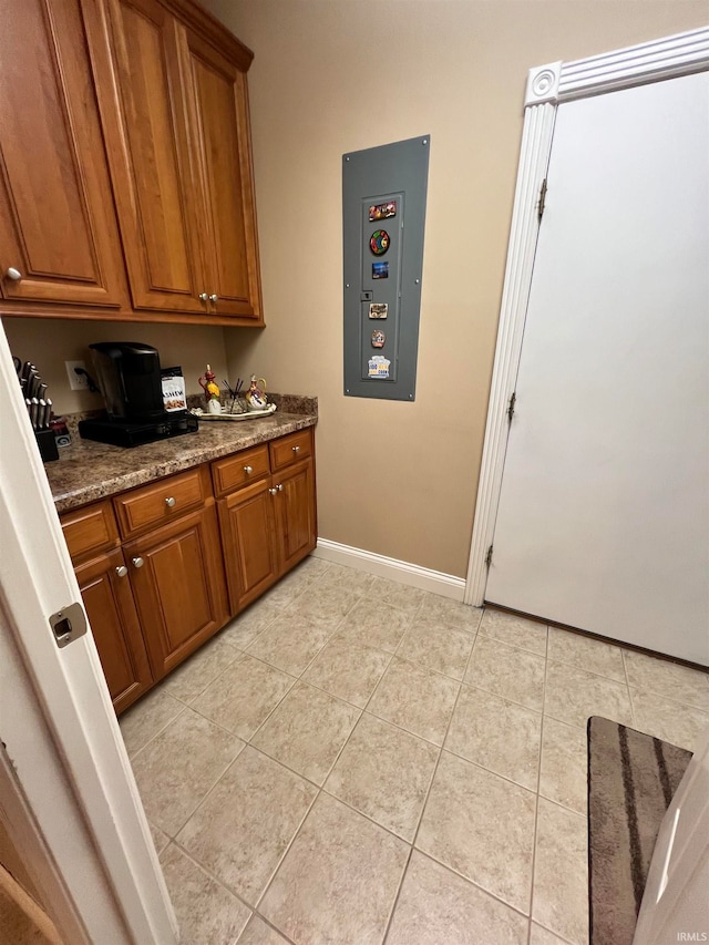 kitchen with light tile patterned floors and dark stone countertops