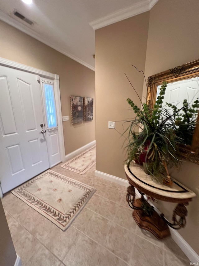 tiled foyer with vaulted ceiling and ornamental molding