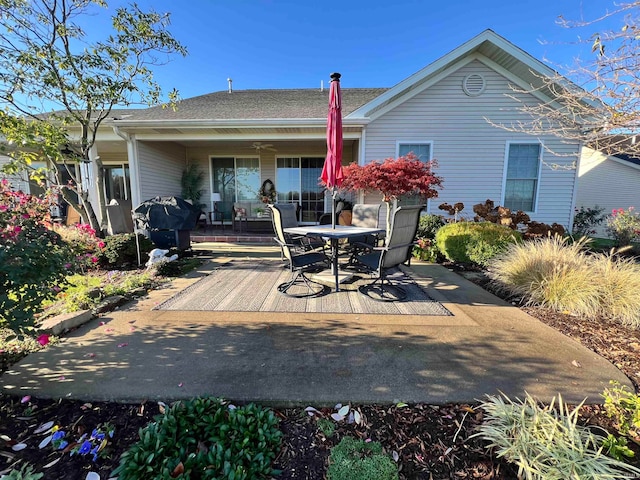 rear view of property featuring ceiling fan and a patio