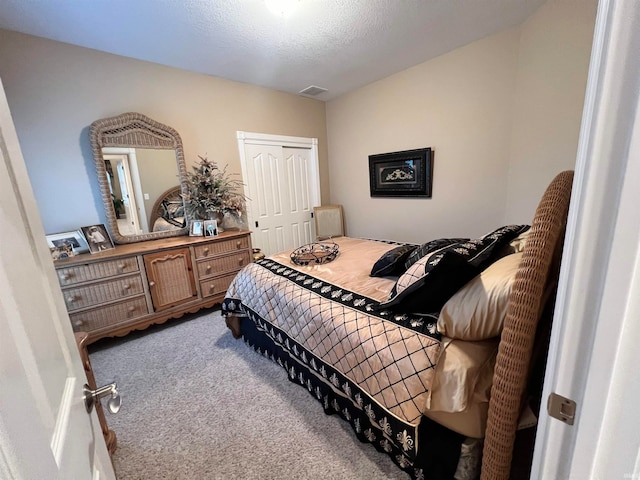 bedroom featuring a textured ceiling, carpet floors, and a closet