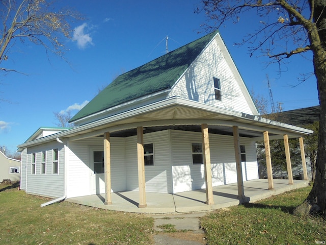 rear view of house with a porch and a yard