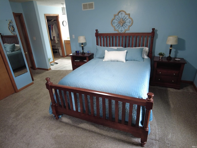 bedroom with light colored carpet, a spacious closet, and a closet