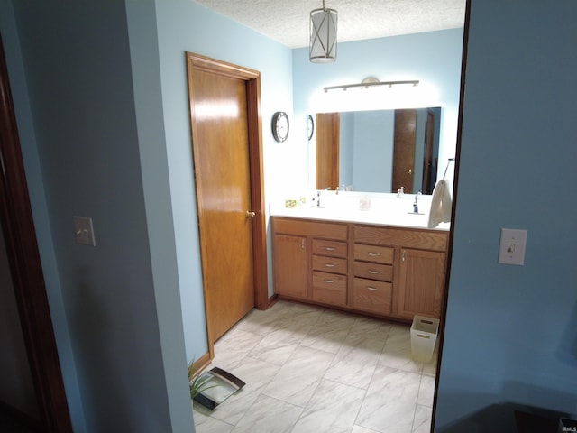 bathroom with vanity and a textured ceiling