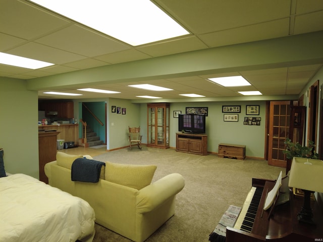 living room with carpet flooring and a paneled ceiling