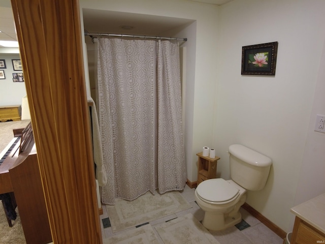 bathroom with tile patterned floors, curtained shower, vanity, and toilet