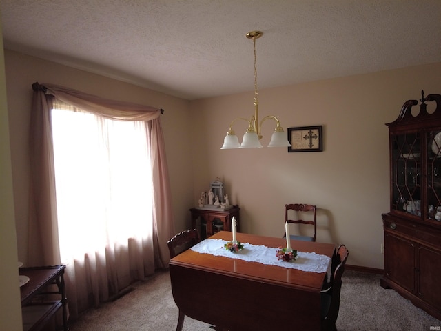 dining room featuring carpet, a textured ceiling, and a chandelier