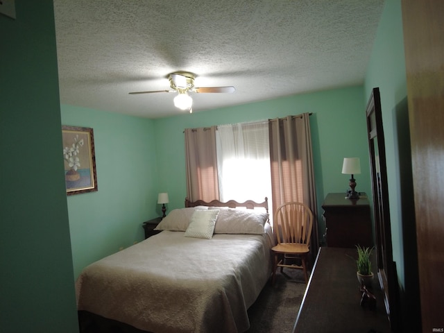 carpeted bedroom with ceiling fan and a textured ceiling