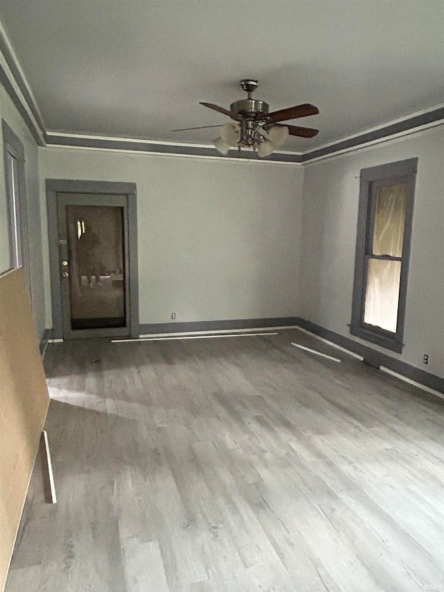 spare room with hardwood / wood-style floors, ceiling fan, and crown molding