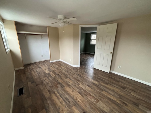 unfurnished bedroom with ceiling fan, a closet, and dark wood-type flooring