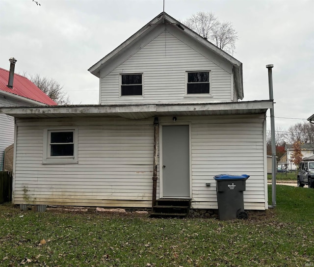 rear view of house featuring a lawn