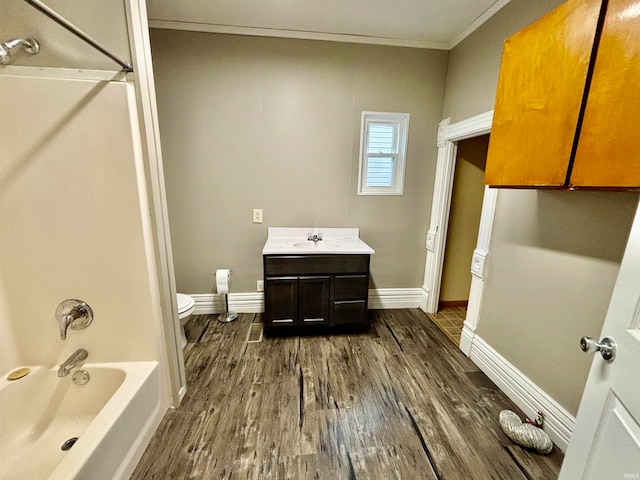 full bathroom featuring  shower combination, vanity, crown molding, hardwood / wood-style floors, and toilet