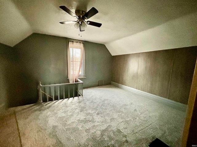 bonus room featuring a textured ceiling, carpet floors, vaulted ceiling, and ceiling fan