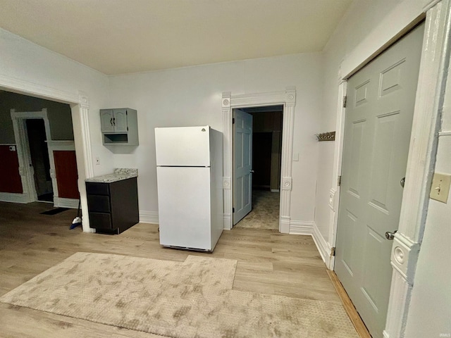 kitchen featuring white refrigerator, light hardwood / wood-style flooring, and gray cabinetry