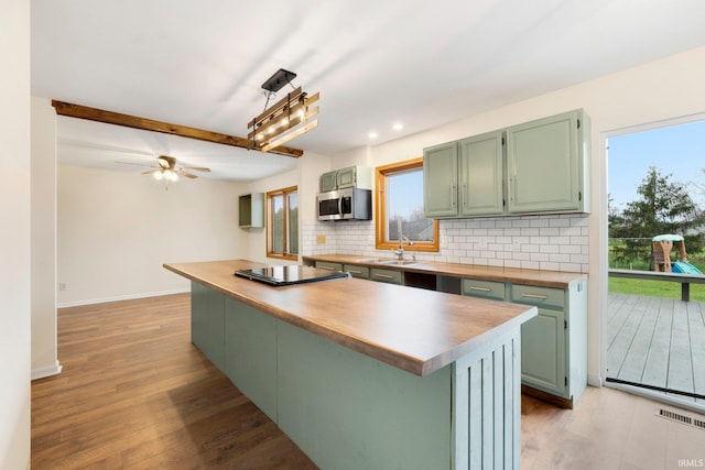 kitchen with a center island, decorative backsplash, light hardwood / wood-style floors, and sink