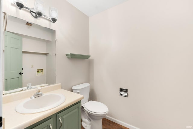 bathroom with wood-type flooring, vanity, and toilet