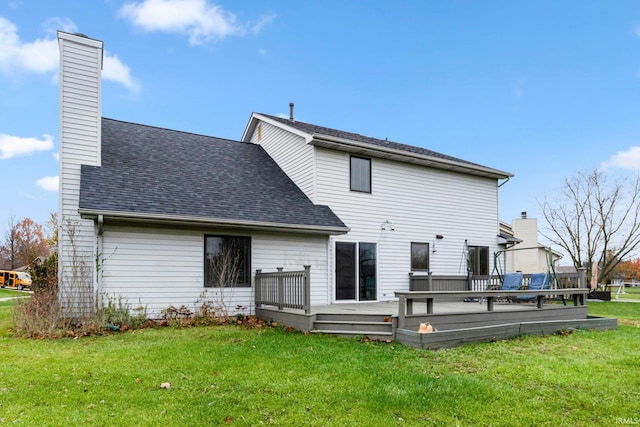 rear view of property featuring a yard and a deck