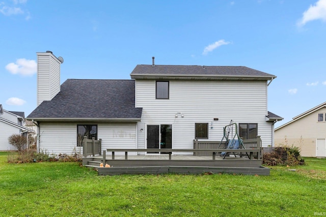 rear view of house with a wooden deck and a yard