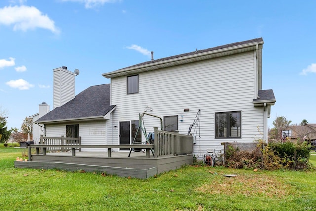 back of property featuring a lawn and a wooden deck