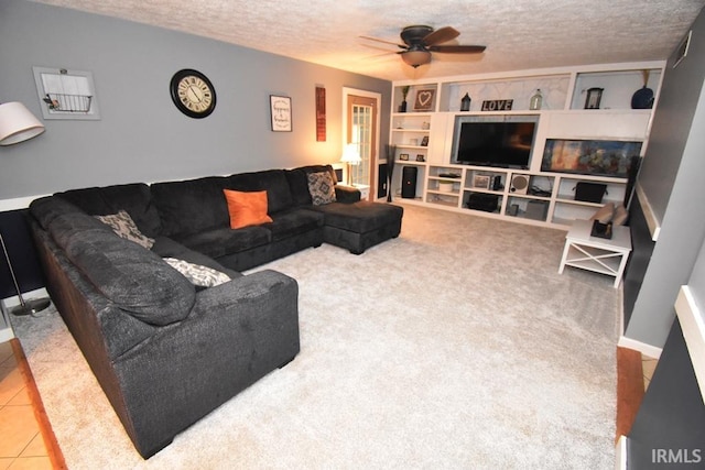 living room with tile patterned flooring, ceiling fan, and a textured ceiling