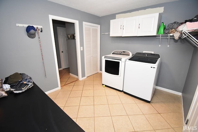 laundry area featuring light tile patterned flooring, cabinets, and separate washer and dryer