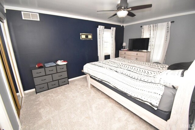 carpeted bedroom with ceiling fan and crown molding