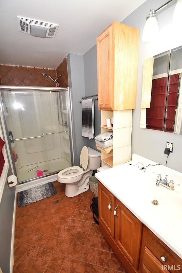 bathroom featuring tile patterned floors, vanity, toilet, and walk in shower