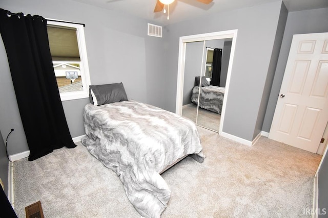 carpeted bedroom featuring a closet and ceiling fan