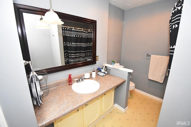 bathroom featuring vanity, toilet, and a textured ceiling