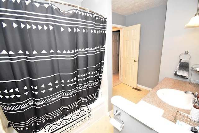 bathroom featuring a textured ceiling, vanity, and walk in shower