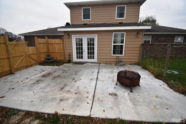 rear view of property featuring french doors and an outdoor fire pit