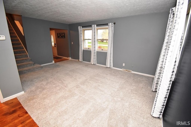 unfurnished room featuring hardwood / wood-style flooring and a textured ceiling