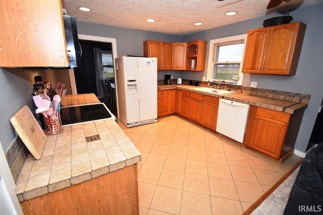 kitchen with a textured ceiling, white appliances, tile countertops, and sink