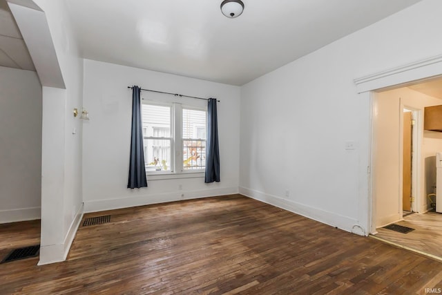 spare room featuring dark wood-type flooring