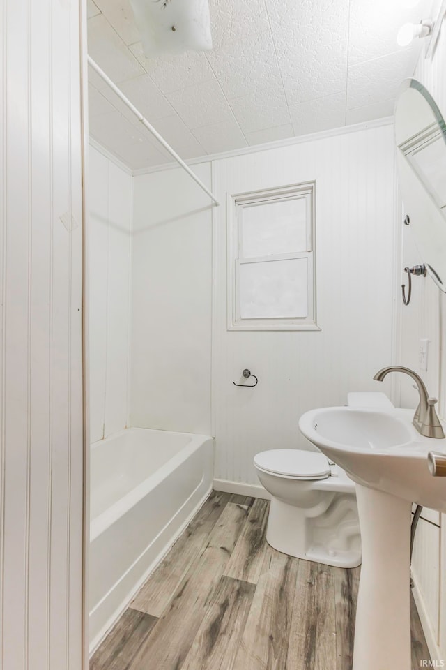 bathroom with  shower combination, hardwood / wood-style flooring, toilet, and wooden walls