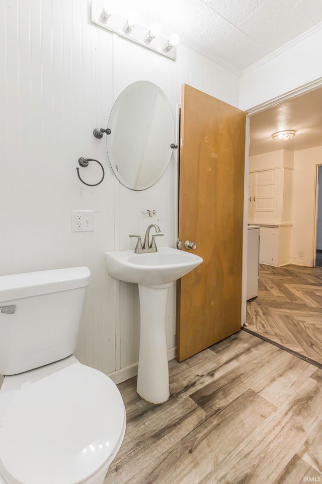 bathroom featuring hardwood / wood-style floors, toilet, and wooden walls