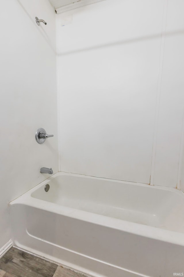 bathroom with hardwood / wood-style flooring and tub / shower combination