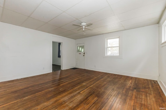 unfurnished room featuring a drop ceiling, ceiling fan, and dark hardwood / wood-style flooring