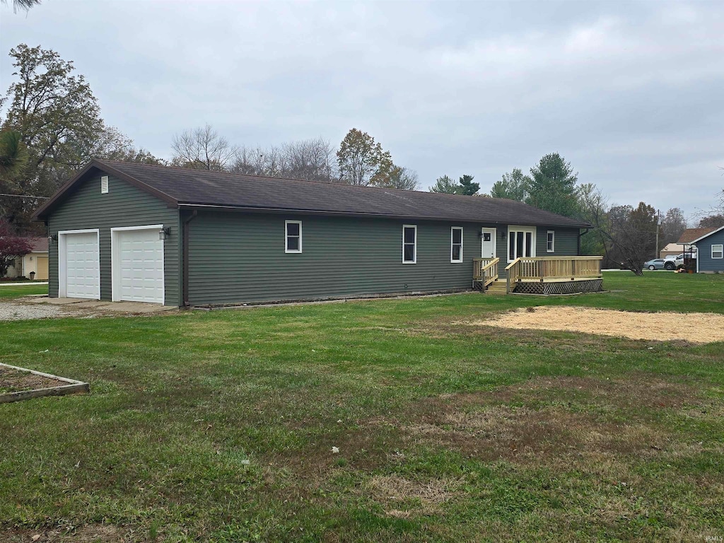 view of front of property with a garage, a front lawn, and a wooden deck