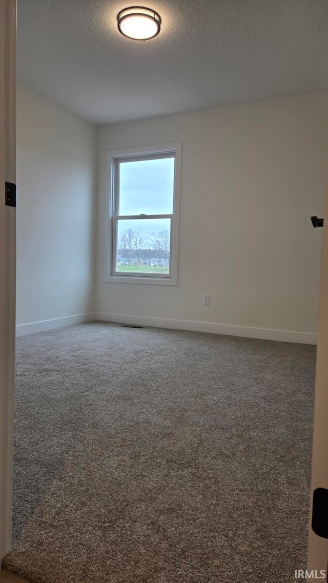 empty room featuring a textured ceiling and carpet floors