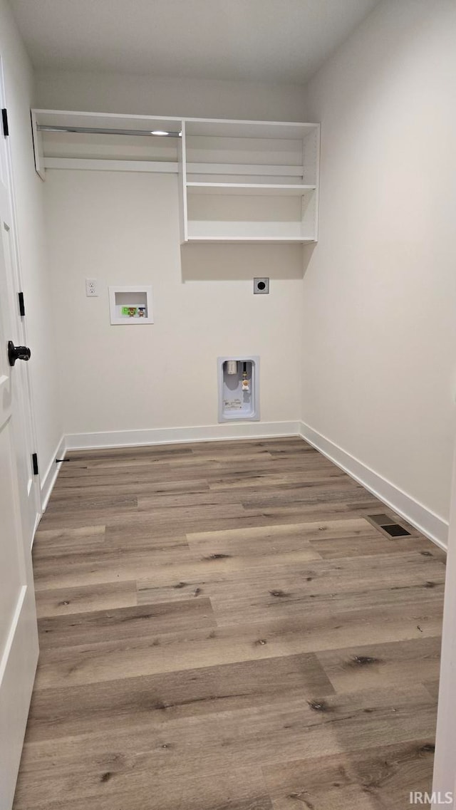 laundry area with washer hookup, electric dryer hookup, and light hardwood / wood-style flooring