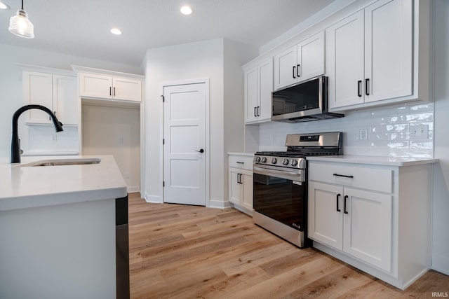 1173 Olympiada Knl, Fort Wayne, IN 46845 - kitchen with stainless steel appliances, a sink, recessed lighting, tasteful backsplash, and light wood-style floors