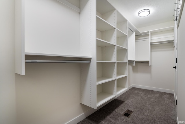 spacious closet featuring dark carpet