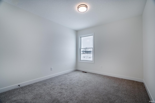 carpeted empty room featuring a textured ceiling