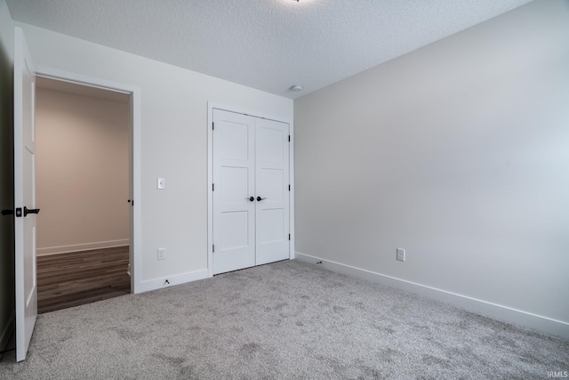 unfurnished bedroom featuring carpet flooring, a closet, and a textured ceiling