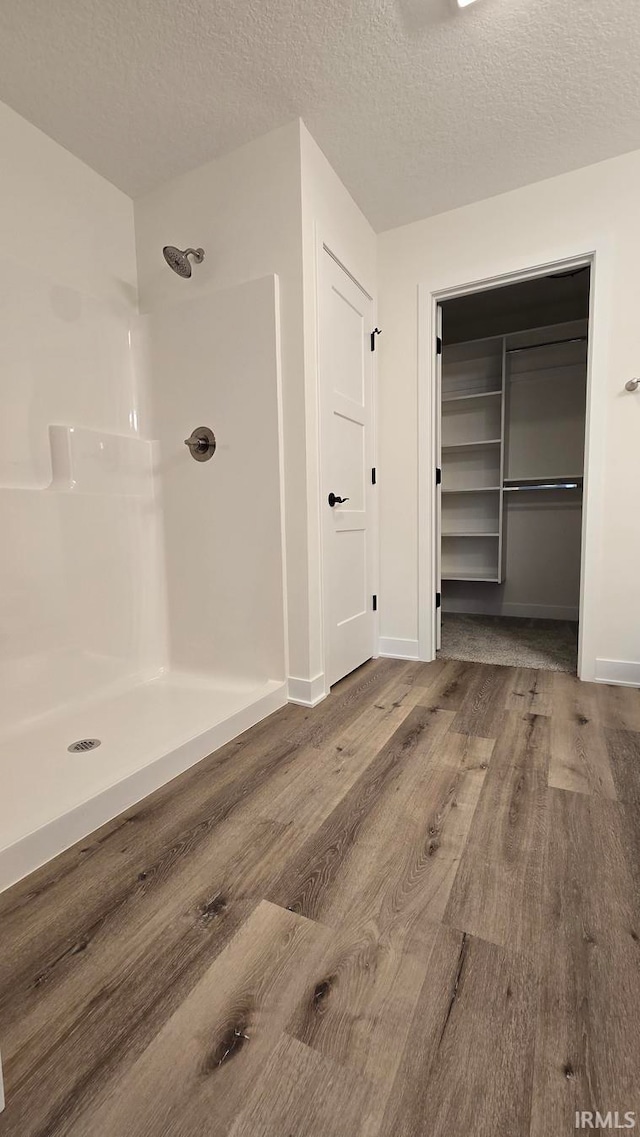 bathroom featuring walk in shower, a textured ceiling, and hardwood / wood-style flooring