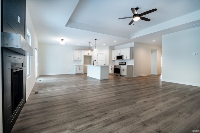 1173 Olympiada Knl, Fort Wayne, IN 46845 - unfurnished living room featuring recessed lighting, a large fireplace, a ceiling fan, a tray ceiling, and baseboards